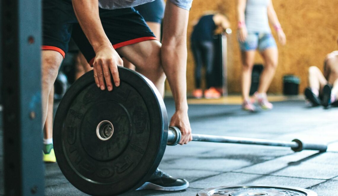 Focused weightlifting session in a gym with diverse athletes participating indoors.