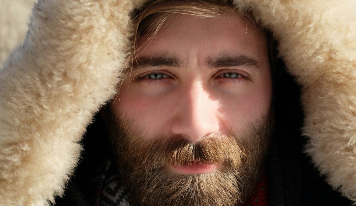 man covered by beige fur textile