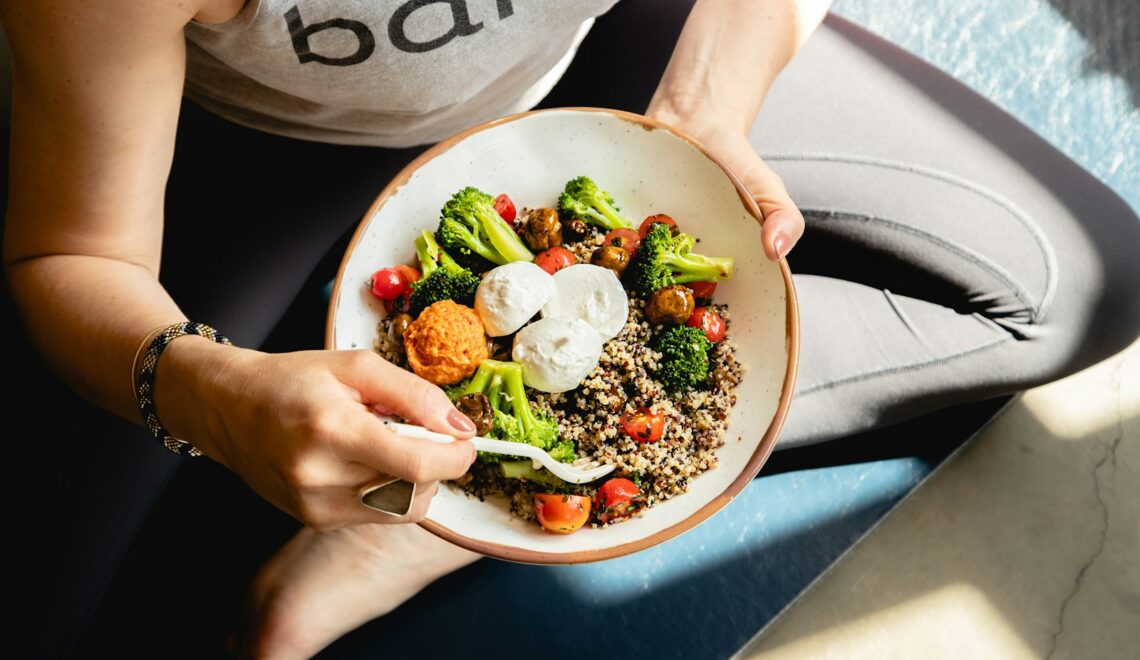 a woman is holding a bowl of food