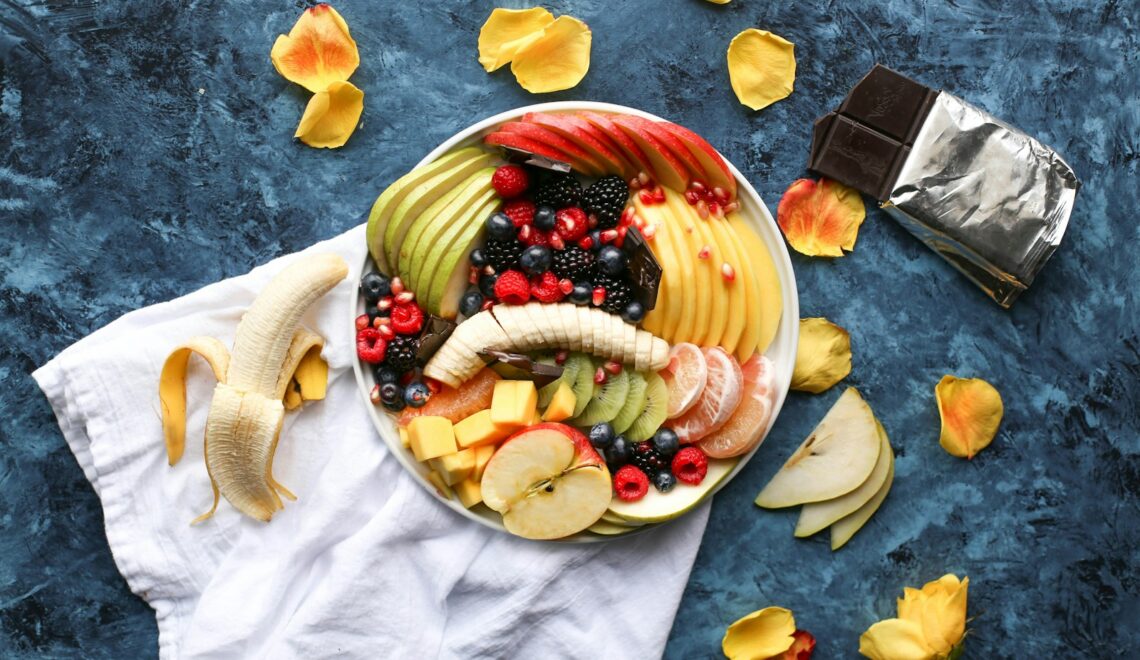 bowl of sliced fruits on white textile